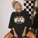 What's the Best That Could Happen retro DTF transfer with pink and yellow distressed lettering in a starburst oval badge on a black oversized tee