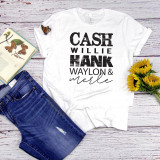 Johnny Cash Willie Hank Waylon Merle Fan Art Sublimation Transfer, a white T-shirt with bold black and cursive text of famous country singers on a rustic wooden surface with blue jeans, an open butterfly book, sunflowers, and a butterfly decoration.