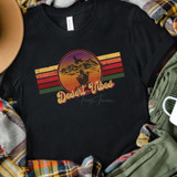 Desert Vibes FINAL STOCK Screen Print Heat Transfer, black T-shirt featuring a retro sunset design with a cactus and mountains, with the text 'Desert Vibes' in a vintage font.