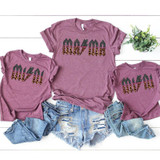MINI ACDC Leopard Glitter YOUTH Screen Print Heat Transfer, set of women's casual t-shirts with AC/DC logo in leopard print and glitter, paired with distressed denim shorts, on a white wooden background with a small green plant.