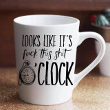 Looks like it's fuck this shit O'clock sublimation transfer on a white ceramic mug, with a clock illustration and bold black text.