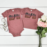 MINI ACDC Leopard Glitter INFANT Screen Print Heat Transfer, pink baby onesie and toddler t-shirt with leopard print AC/DC logo, next to white sneakers and pink and white roses.