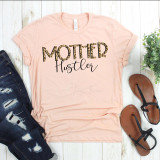 Mother Hustler Screen Print Heat Transfer, design on light pink T-shirt with leopard print and black cursive text, displayed with distressed jeans, sandals, and greenery.
