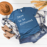 Dare to Be Different Screen Print Heat Transfer T-Shirt, blue casual t-shirt with white motivational text, laid out on white wooden surface with accessories.