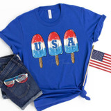 USA Bomb Pop Screen Print Heat Transfer, vibrant blue T-shirt featuring patriotic American flag-themed ice pop graphics spelling 'USA'.