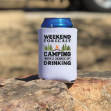 Weekend Forecast Drinking Can Hugger Screen Print Heat Transfer, a white can cooler with humorous camping and drinking quote displayed outdoors on a rock.