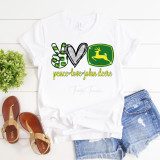 Peace Love John Deere Sublimation Transfer, white T-shirt with Peace sign, heart, and John Deere logo design, along with the text peace love john deere, paired with denim shorts and tan sandals.