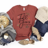 Fall for Jesus He Never Leaves Screen Print Transfer, a graphic t-shirt with fall leaves and inspirational text, surrounded by fall-themed accessories and clothing items.
