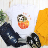 Happy Fall Ya'll Sloth Sublimation Transfer, a white T-shirt featuring a cute watercolor illustration of a sloth's face emerging from a pumpkin with Autumn-themed text.