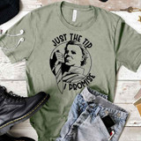Just The Tip Screen Print Transfer, graphic t-shirt with a bold illustration of a woman holding a knife and the text "Just The Tip I Promise" in black on a green shirt.