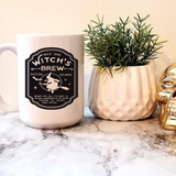 Witch's Brew Potion Sublimation Transfer, a black and white graphic design on a coffee mug with a witch flying on a broomstick and detailed text.