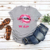 Wet Lips Screen FINAL STOCK Print Heat Transfer, graphic design on a gray t-shirt with pink lips and splashes, casual outfit with denim shorts and brown sandals.