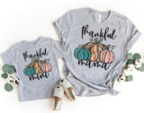 Thankful Mini Pumpkins YOUTH Screen Print Heat Transfer on matching grey T-shirts for mom and child, featuring colorful pumpkin illustrations and the words 'thankful mom' and 'thankful mama' in black script, seasonal autumn theme.
