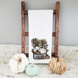 Farm Fresh Pumpkins Tea Towel Screen Print Heat Transfer, white tea towel with pumpkin and pumpkin plant design hanging on a wooden ladder, surrounded by white, mint, and natural fiber pumpkins.