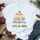 Maybe Christmas Means A Little Bit More Sublimation Transfer, white T-shirt with Christmas-themed quote and green star graphic, festive holiday decorations surrounding it.