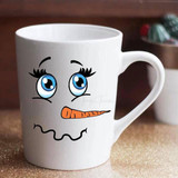 Snowman Face Sublimation Transfer, white ceramic mug with cute snowman face design featuring big blue eyes, an orange carrot nose, and a wavy mouth.