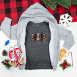 Patterned Trees YOUTH Screen Print Heat Transfer, gray and leopard print tree design on a dark gray shirt surrounded by Christmas decorations.