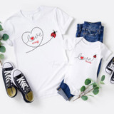 Love Bug Sublimation Transfer, two white T-shirts with love bug designs and text, paired with denim jeans and sneakers, flat lay on a white background.