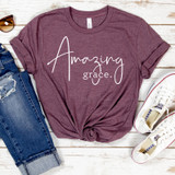 Amazing Grace Screen Print Heat Transfer, maroon t-shirt with 'Amazing Grace' text design displayed alongside distressed jeans and white sneakers on a white wooden surface.