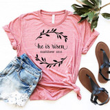 He Is Risen Easter Sublimation Transfer, pink T-shirt with black text and leaf design for Easter celebration.