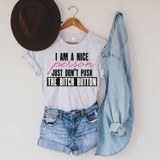 I Am A Nice Person Sublimation Transfer, casual outfit with a printed t-shirt, denim shorts, a denim shirt, and a brown hat hanging on a wall.