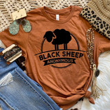 Black Sheep Screen Print Heat Transfer, black silhouette of a sheep with the text 'Black Sheep' and 'Anonymous' underneath it on a burnt orange T-shirt.