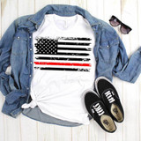Flag With Thin Red Line Sublimation Transfer, a graphic T-shirt featuring a black and red American flag design with a distressed style, laid on a wooden surface with a denim jacket, sunglasses, and Vans shoes.
