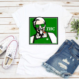 THC Sublimation Transfer, graphic design of an elderly man with sunglasses, a cigar, and a marijuana leaf on his apron displayed on a white t-shirt.