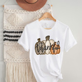 Thankful Pumpkins Sublimation Transfer, white t-shirt with a design of four pumpkins in different patterns and colors with the word 'thankful' written across them.