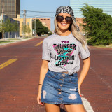 The Thunder Rolls DTF Transfer, a colorful heat transfer design on a woman's graphic T-shirt with vibrant text and graphic elements.