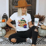 Legends Never Die DTF Transfer, product featuring a colorful design of animated characters and the text 'Legends Never Die' on a white T-shirt worn by a cheerful woman sitting on the floor with pumpkins and autumn decorations around.