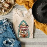 Spooky Season Screen Print Heat Transfer, Halloween-themed graphic t-shirt displayed with jeans, a black hat, and seasonal decorations.