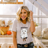 Boooooo! Cow DTF Transfer, a woman wearing a graphic t-shirt with a cartoon cow and the word "BOOOOOOO!" printed on it, in a market setting with pumpkins and agricultural produce.