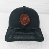 Lion Mascot Leather Hat Patch, a black and gray baseball cap with a lion face patch on the front.