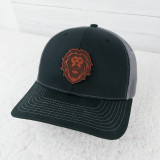 Lion Mascot Leather Hat Patch, embroidered lion head logo on a black and gray baseball cap.