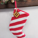Custom Initial TAN Leather Patch Christmas Stocking, red and white striped Christmas stocking with a leather initial patch hanging from a pink knitted loop.