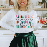 Santa Claus Hot Chocolate Words Screen Print Transfer, colorful Christmas-themed design on a white long-sleeve shirt.