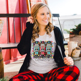 Nuts About Christmas DTF Transfer, colorful nutcracker design for holiday decoration on a white t-shirt worn by a smiling woman.