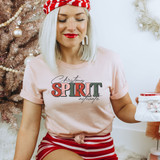 Christmas Spirit Activate DTF Transfer, festive woman wearing a pink t-shirt with Christmas-themed design, holiday decorations in background.