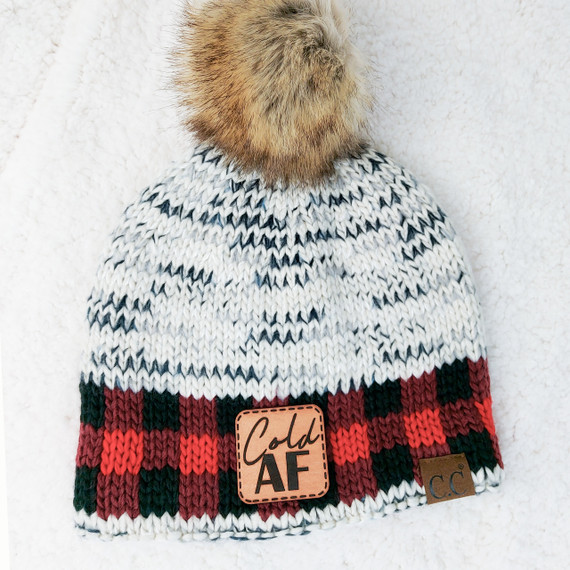 Cold AF Leather Patch, knitted winter beanie with faux fur pom-pom featuring a leather patch with the brand name and a decorative label.