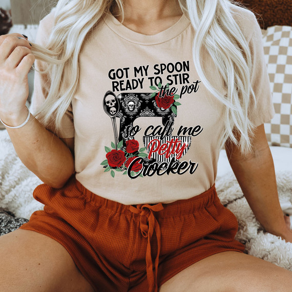 Got My Spoon Ready To Stir The Pot DTF Heat Transfer, a humorous T-shirt design featuring skulls, roses, and a chef's spatula with text.