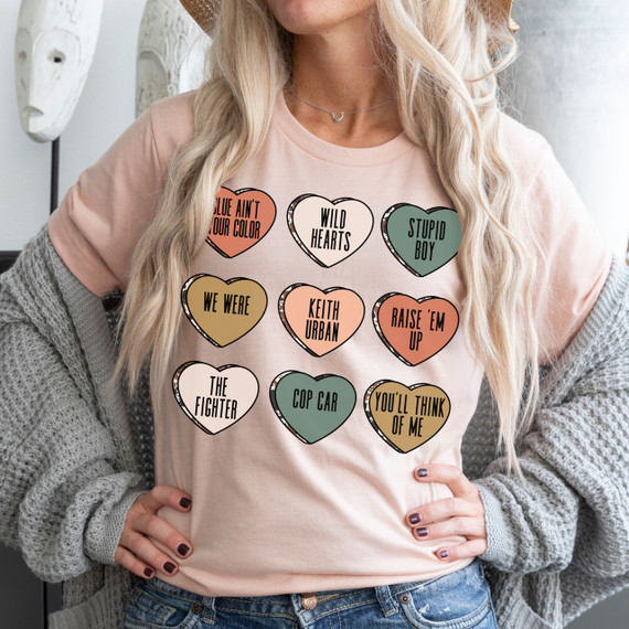 Keith Candy Hearts DTF Heat Transfer, colorful heart-shaped designs with various phrases printed on a woman's t-shirt.
