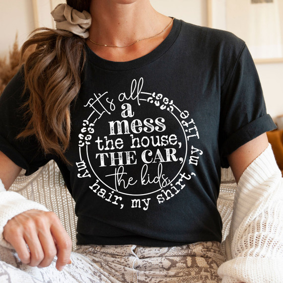 It's All Messy WHITE Screen Print Heat Transfer, humorous white text design on a black t-shirt reading 'It's all a mess the house, the car, the kids, my shirt'.