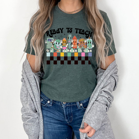 Ready To Teach DTF Heat Transfer, colorful cartoon characters and text on a green T-shirt worn by a woman.