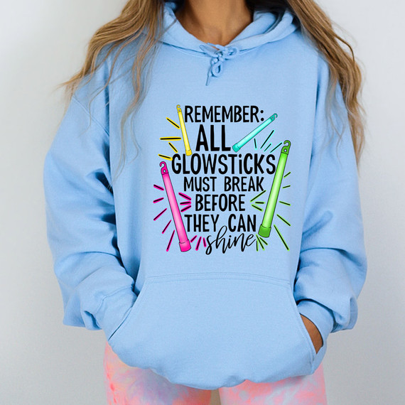 Remember All Glow Sticks Must Break Before They Can Shine, DTF Heat Transfer, folded brightly colored glow sticks and text on a light blue hoodie.