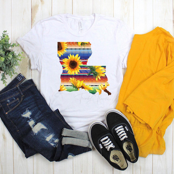 Serape Sunflower Louisiana print Sublimation Transfer, colorful design on a white T-shirt with sunflowers and striped pattern, paired with jeans, sneakers, and a yellow jacket for a casual style.