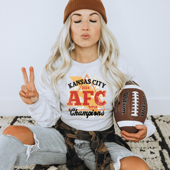 KC Champs DTF Heat Transfer, a printed design on a woman's sweatshirt celebrating Kansas City 2024 AFC Championship with football and victory graphics.