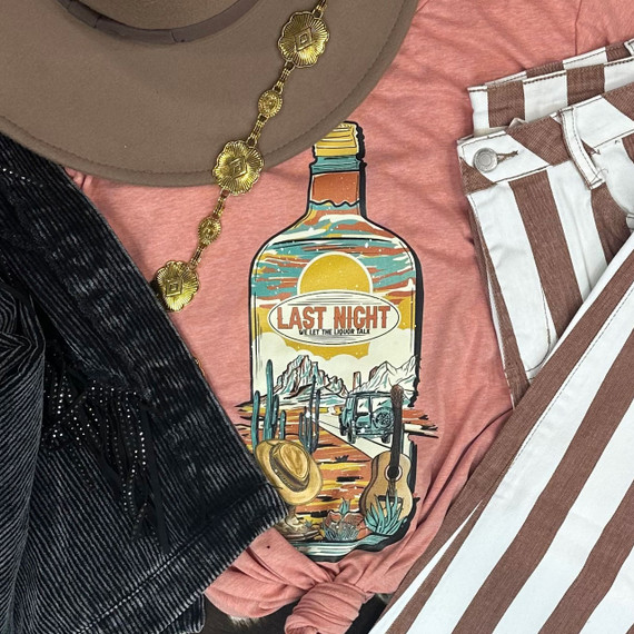 Last Night Liquor Screen Print Heat Transfer, colorful graphic of a liquor bottle with desert scene, mountains, cactus, guitar, and car, on pink fabric.