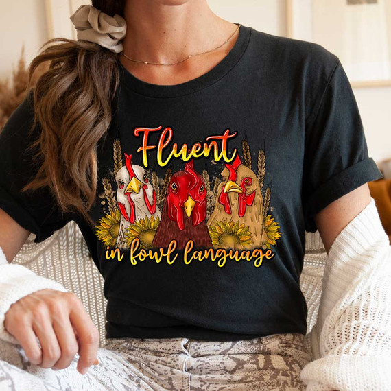 Fluent In Fowl Language DTF Heat Transfer T-shirt with graphic of three animated chickens and the phrase "Fluent in fowl language" in a fun, colorful design.