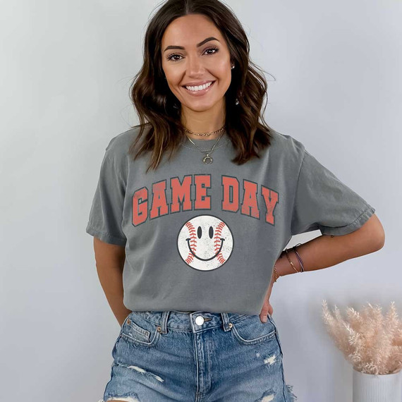 Game Day Retro DTF Heat Transfer, woman wearing a gray t-shirt with 'GAME DAY' text and smiling baseball graphic.